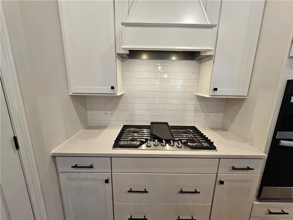 a kitchen with white cabinets and white appliances
