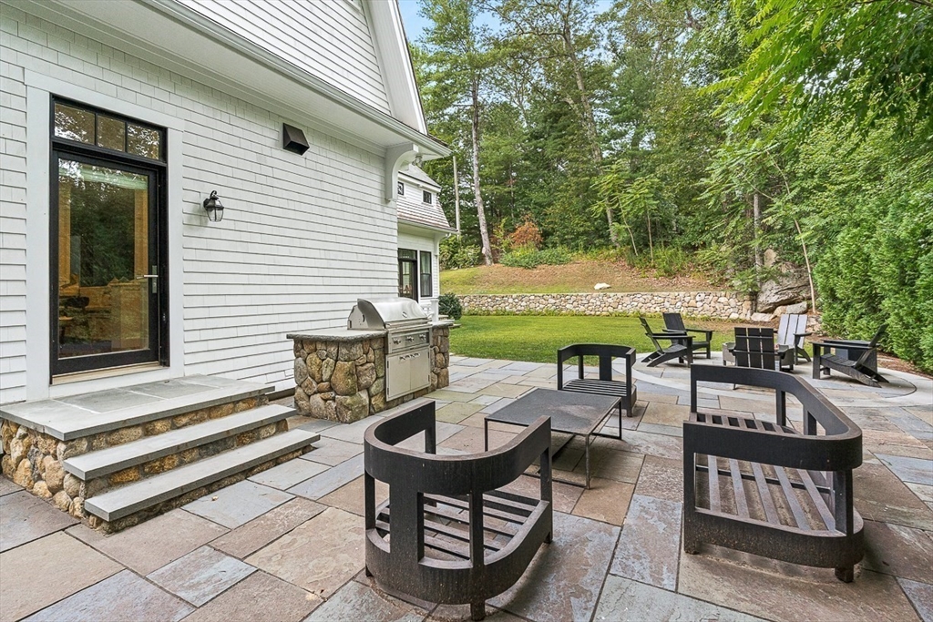 168 Beaver Road Weston, MA 02493 - Photo 23 of 27 a backyard of a house with barbeque oven table and chairs
