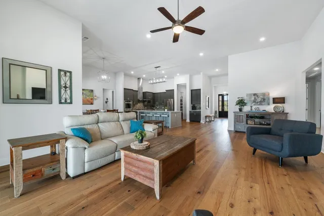 a living room with furniture and a view of kitchen