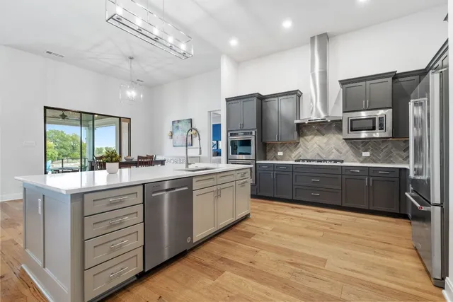 a large kitchen with stainless steel appliances kitchen island granite countertop a sink counter space cabinets and stainless steel appliances