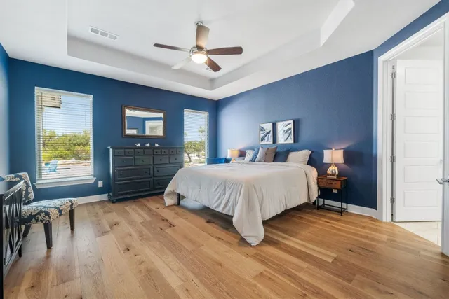 a bedroom with a large bed chandelier and a window