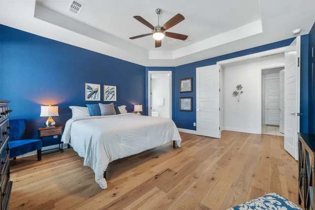 a bedroom with a large bed and a chandelier