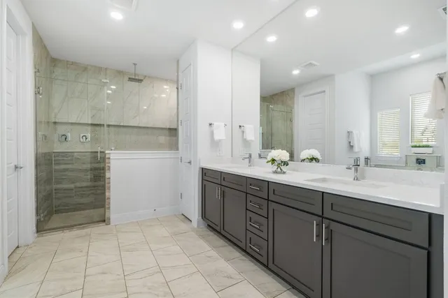 a bathroom with a double vanity sink mirror and shower