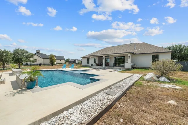 a view of a house with a backyard and a patio