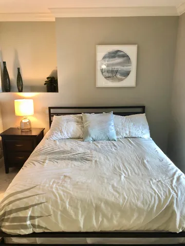 a bedroom with a bed and a night stand