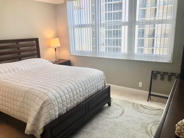 a bedroom with a bed and a large window