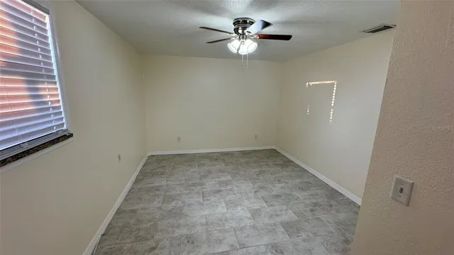 an empty room with closet and windows
