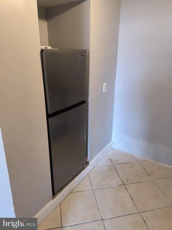 a view of an empty room with wooden floor and closet