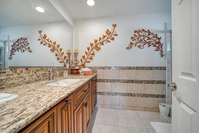 a bathroom with a glass shower door and a sink