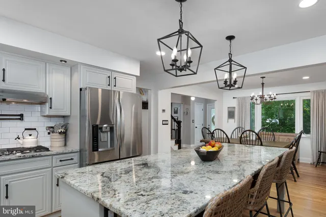 a kitchen with stainless steel appliances granite countertop a sink a stove and refrigerator