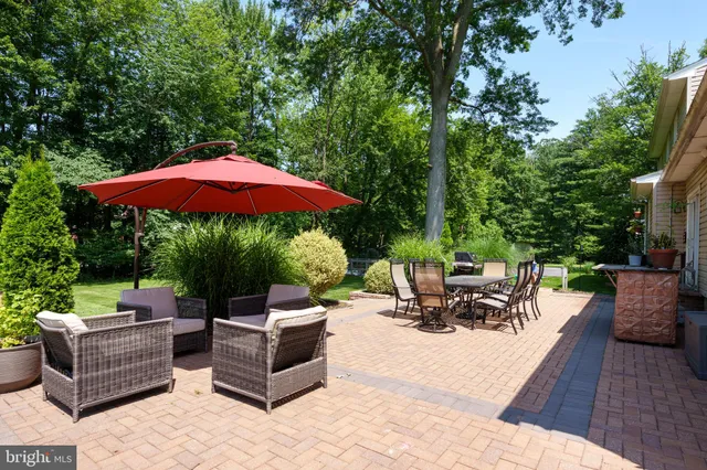 a view of a patio with couches chairs and a umbrella