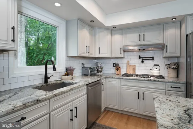 a kitchen with kitchen island white cabinets and white appliances