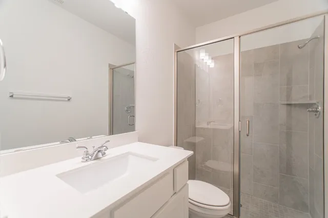 a bathroom with a sink toilet vanity and shower