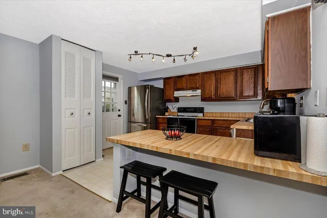 a kitchen with a sink a stove a refrigerator and cabinetry