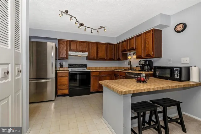 a kitchen with granite countertop wooden cabinets and white appliances