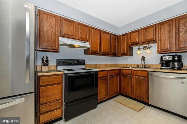 a kitchen with stainless steel appliances granite countertop a refrigerator stove and sink