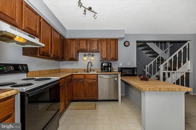 a kitchen with appliances a sink and cabinets