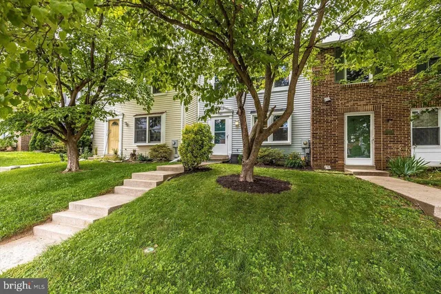 a front view of a house with yard and green space