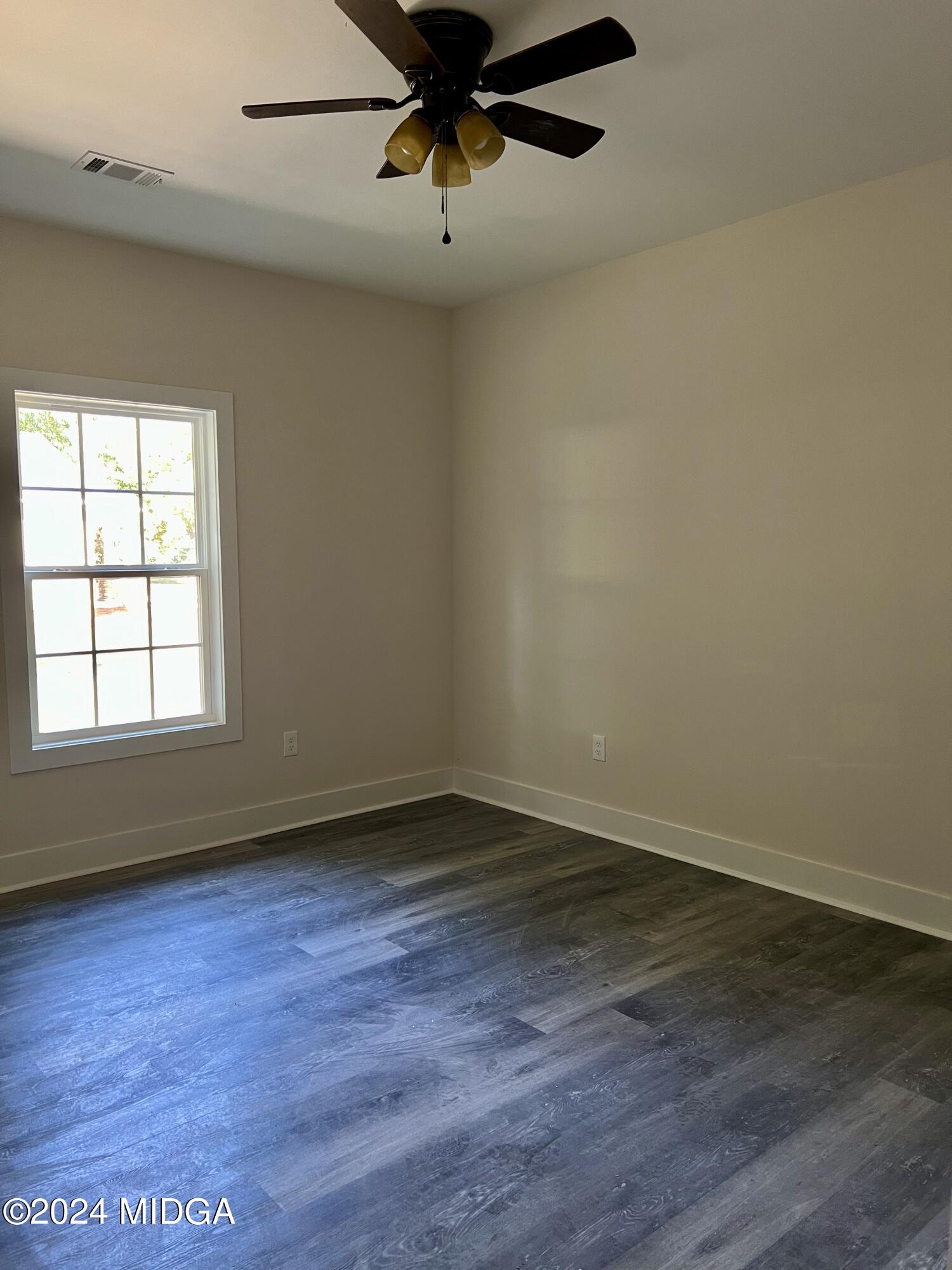 450 Walker Road Byron, GA 31008 - Photo 12 of 22 a view of an empty room with wooden floor and a window