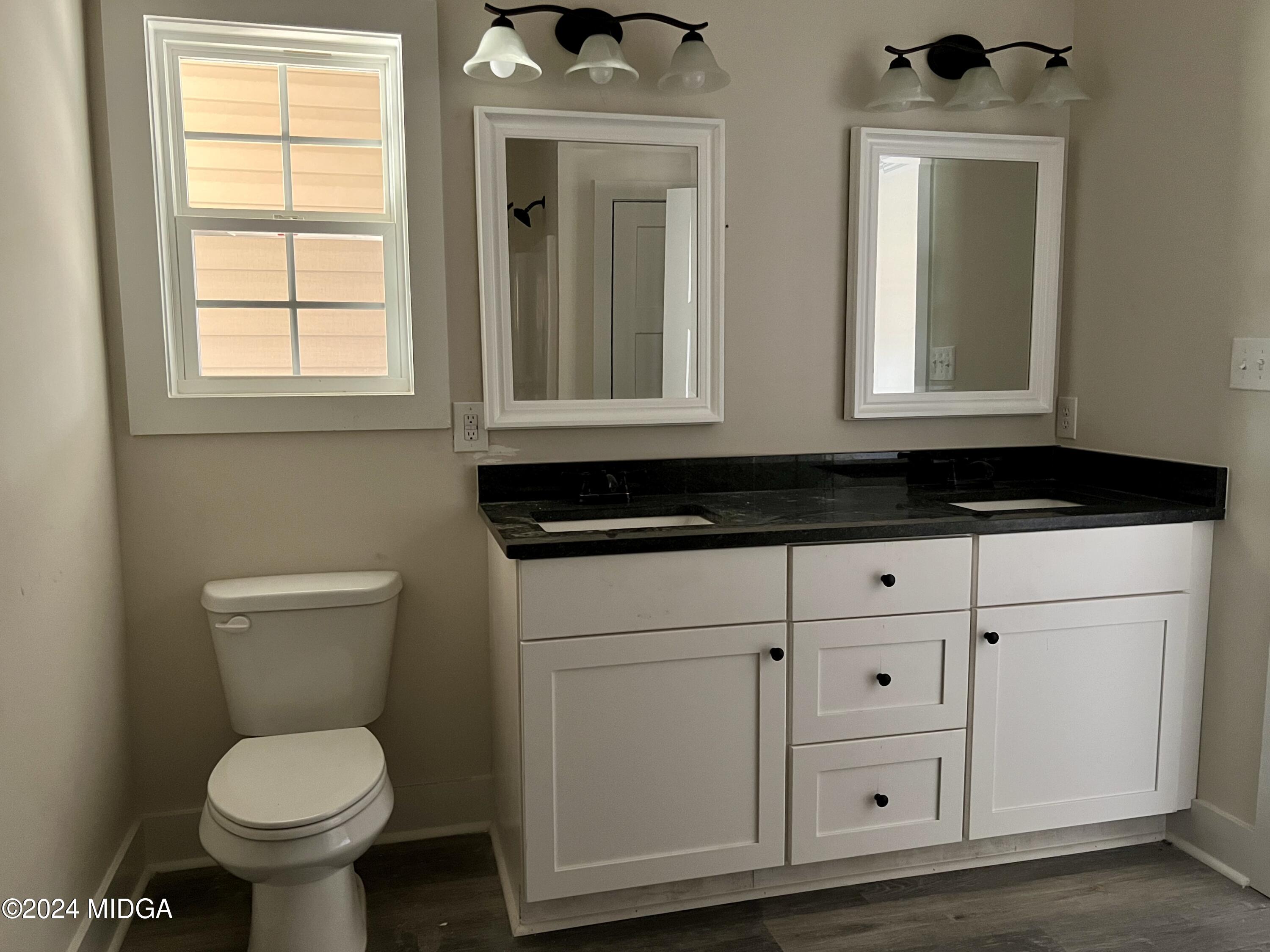 450 Walker Road Byron, GA 31008 - Photo 18 of 22 a bathroom with a toilet a sink and mirror