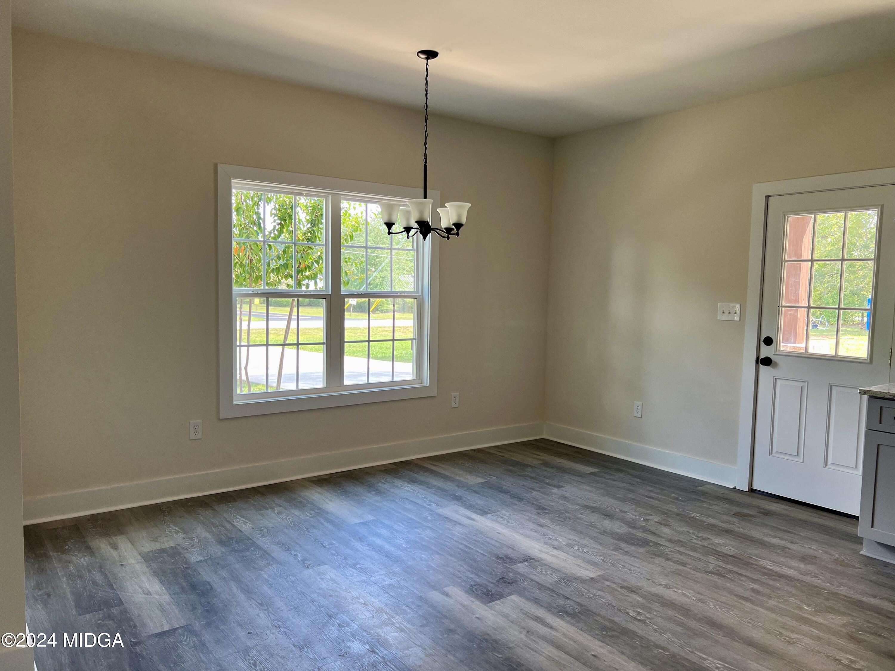 450 Walker Road Byron, GA 31008 - Photo 5 of 22 an empty room with wooden floor and windows