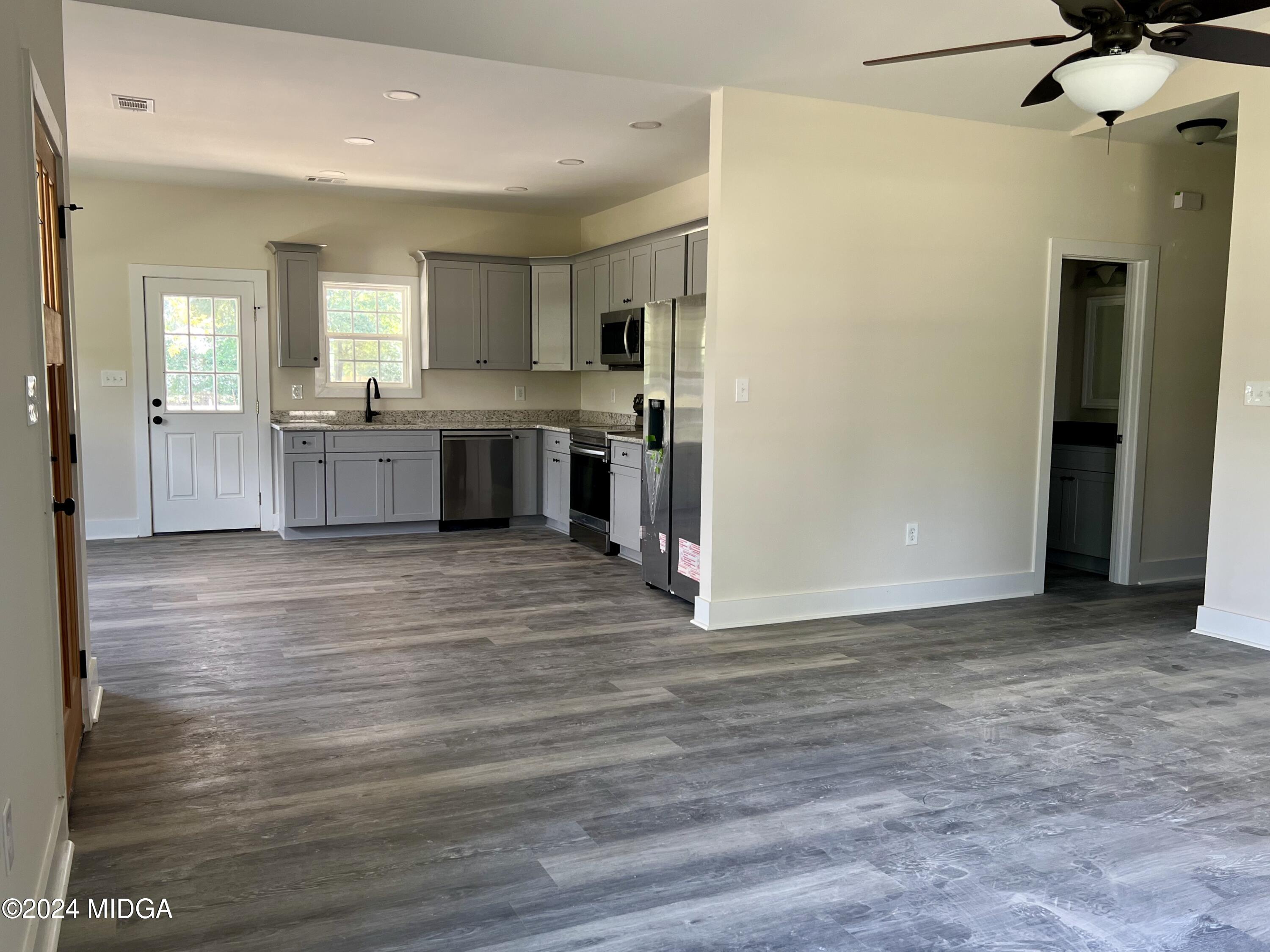 450 Walker Road Byron, GA 31008 - Photo 9 of 22 a view of a kitchen with a refrigerator and a stove top oven
