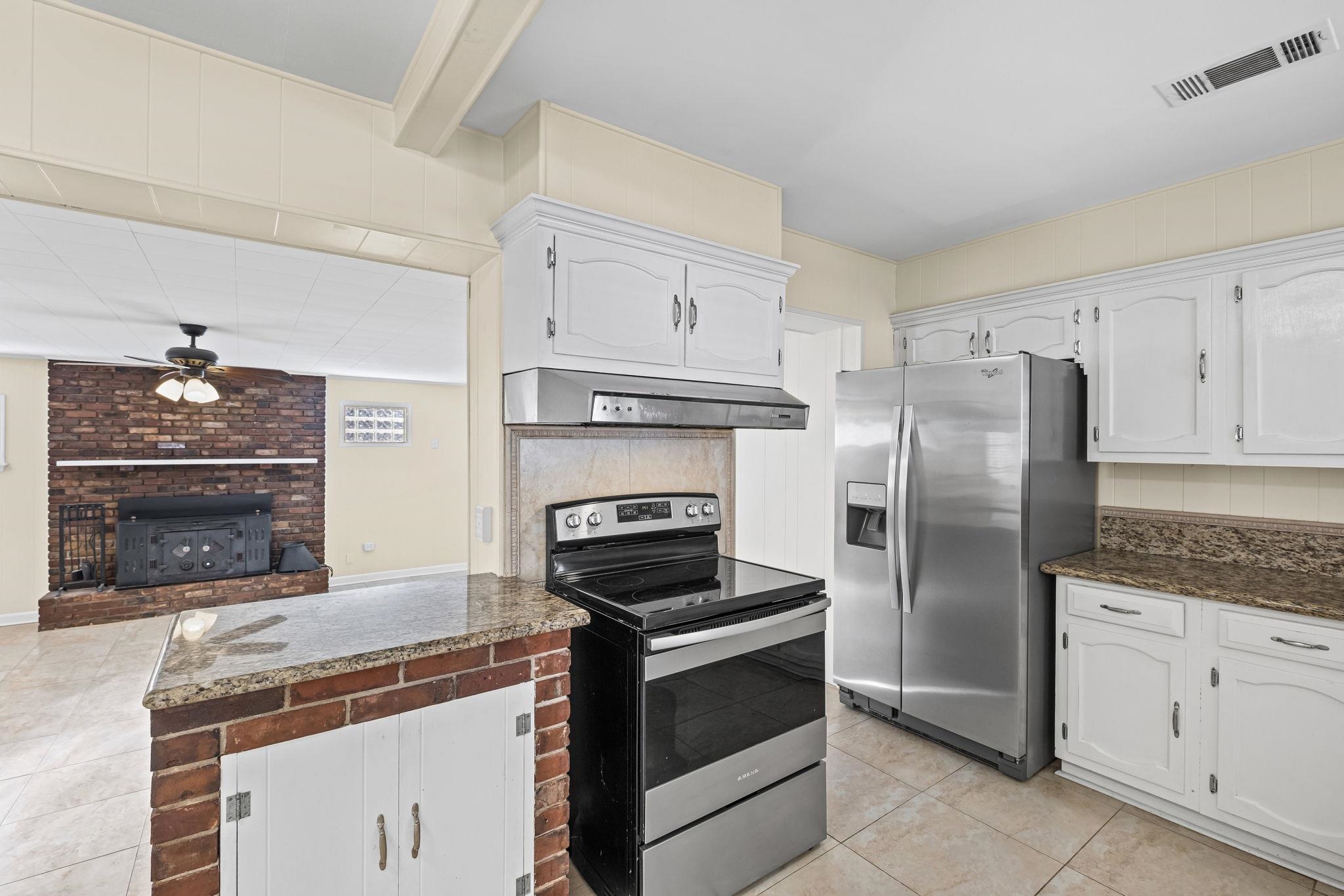 5037 Dee Road Memphis, TN 38117 - Photo 11 of 28 a kitchen with granite countertop a stove microwave and refrigerator