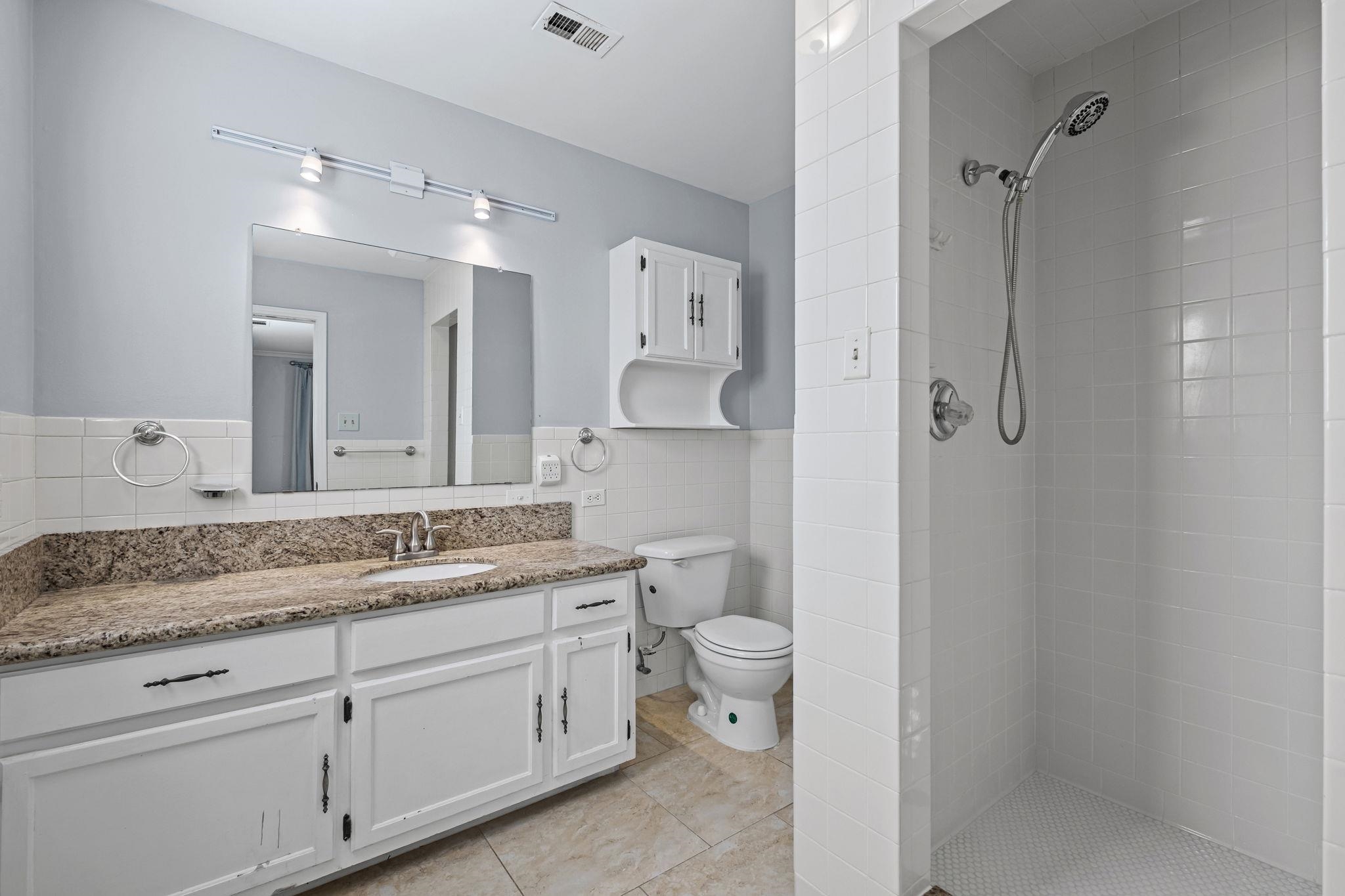 5037 Dee Road Memphis, TN 38117 - Photo 22 of 28 a spacious bathroom with a granite countertop sink mirror and toilet
