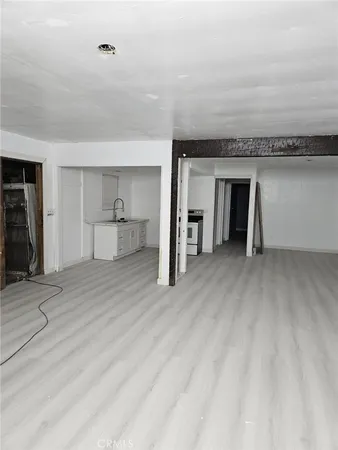 a view of a room with wooden floor and entryway