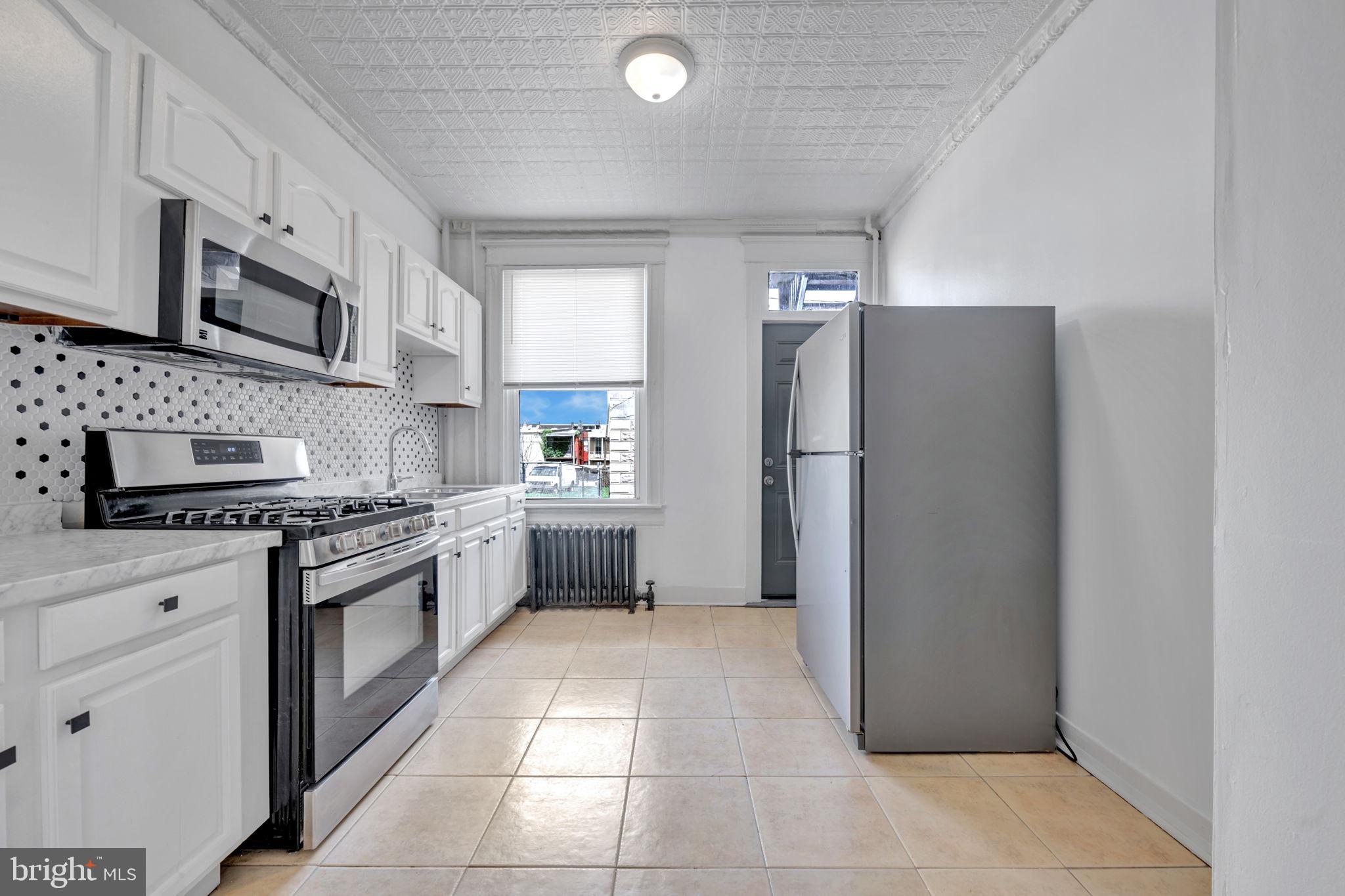2822 Riggs Avenue Baltimore, MD 21216 - Photo 12 of 30 a kitchen with stainless steel appliances granite countertop a refrigerator and a stove