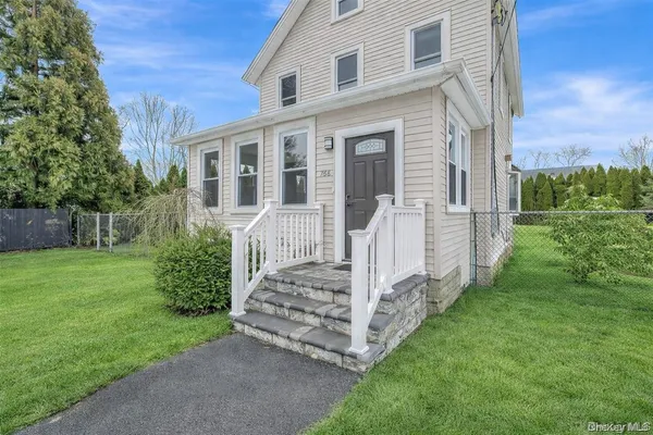 a view of a house with backyard and a yard