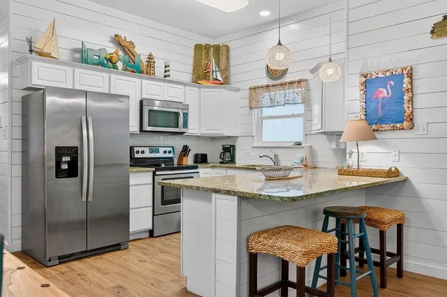 a kitchen with stainless steel appliances granite countertop a sink a refrigerator and a stove