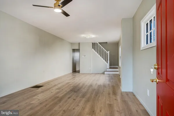 a view of a livingroom with wooden floor and staircase
