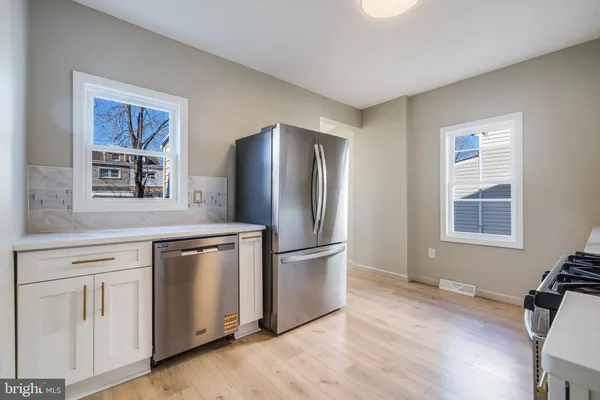 a kitchen with stainless steel appliances granite countertop a refrigerator and a stove top oven