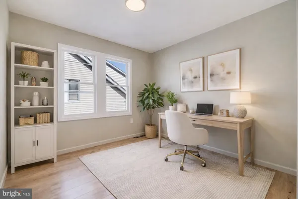 a view of a workspace with furniture and a window