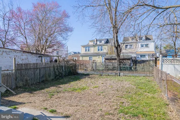 a view of a yard in front of a house with a fence