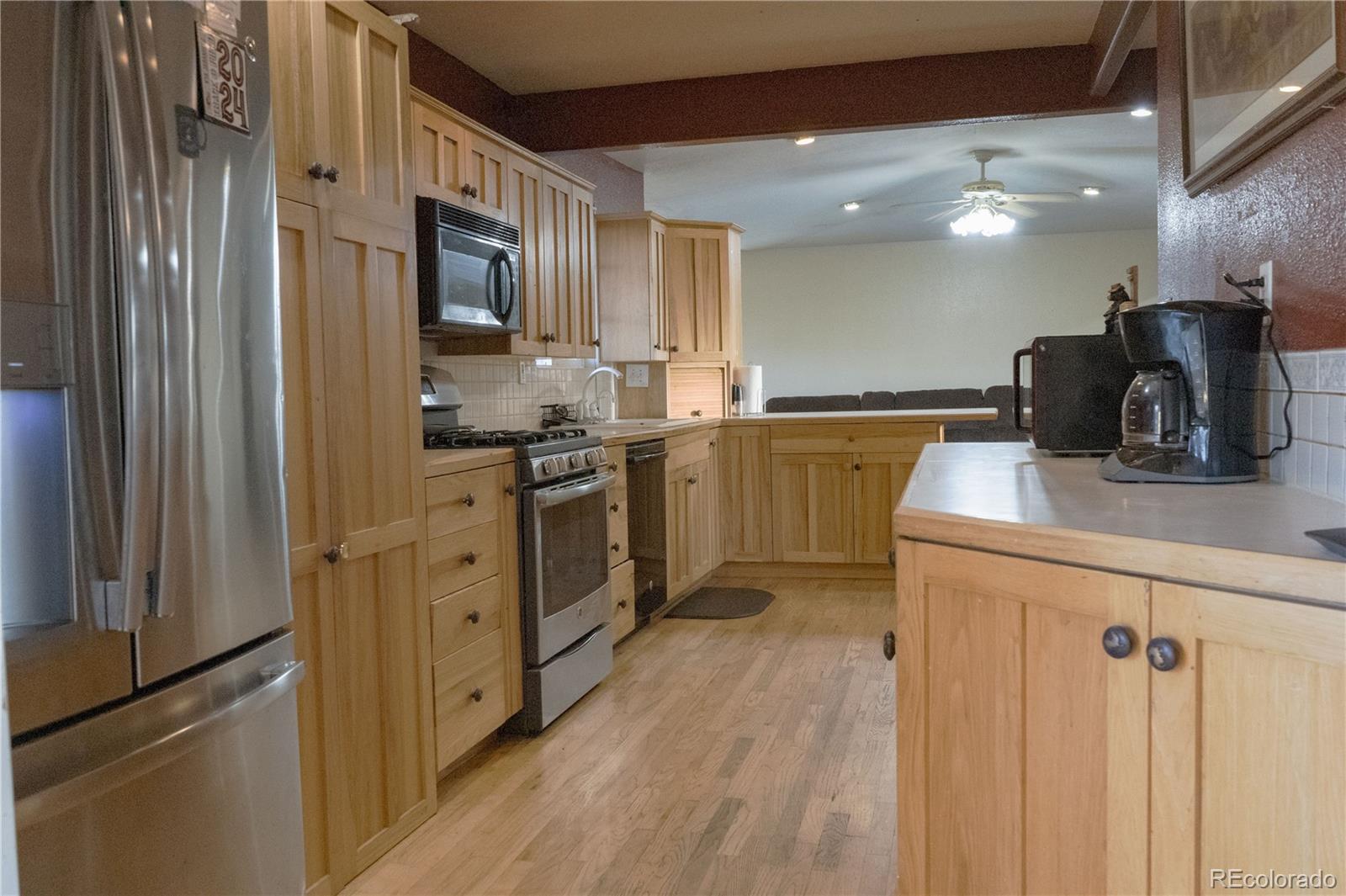 17150 County Rd PP Wray, CO 80758 - Photo 33 of 48 a kitchen with stainless steel appliances granite countertop a refrigerator a sink dishwasher a stove and a dining table with wooden floor