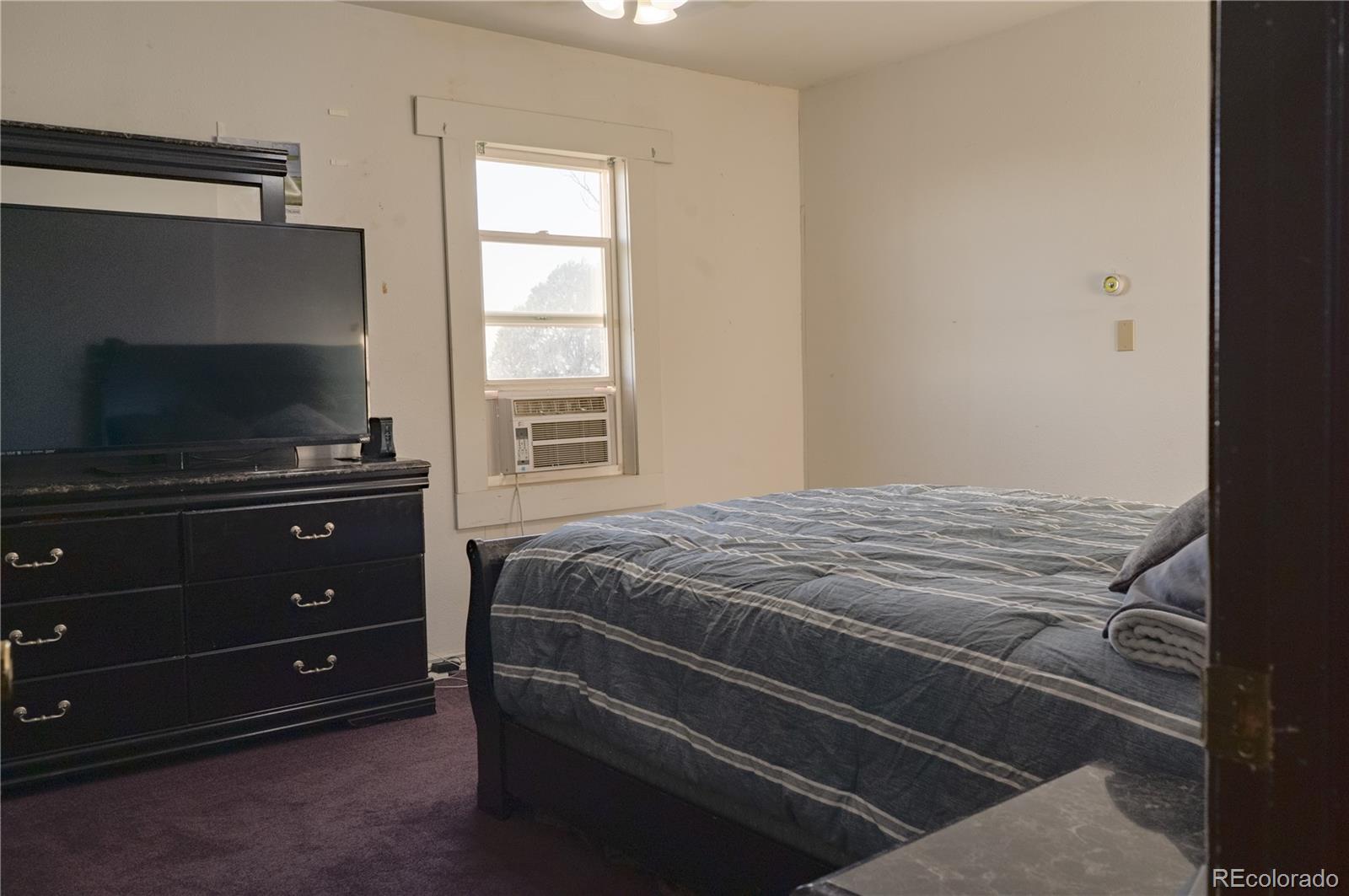 17150 County Rd PP Wray, CO 80758 - Photo 37 of 48 a bedroom with a bed and a flat tv screen on dresser