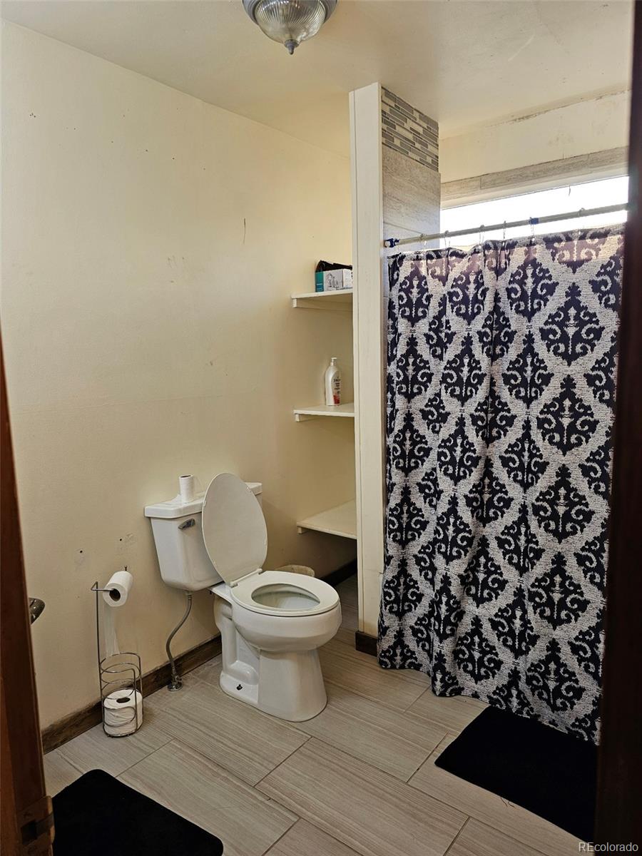 17150 County Rd PP Wray, CO 80758 - Photo 38 of 48 a bathroom with a toilet and a shower curtain