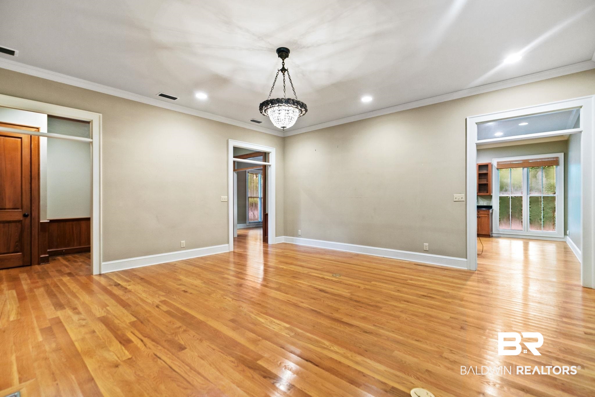 202 Beall Lane Daphne, AL 36526 - Photo 12 of 46 Spare room featuring crown molding, light hardwood / wood-style flooring, and a notable chandelier
