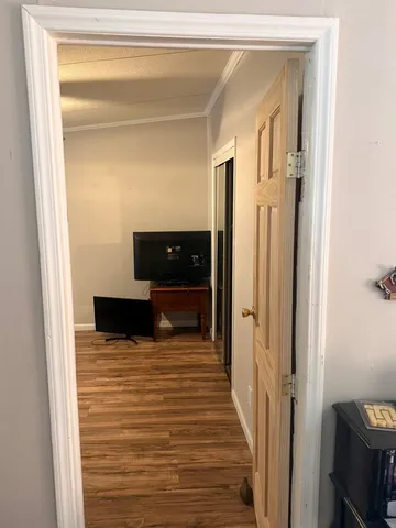 a view of a hallway with wooden floor and staircase