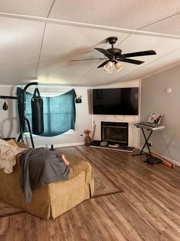 a bedroom with a bed a fireplace and a ceiling fan