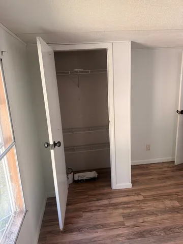 an empty room with wooden floor and a window