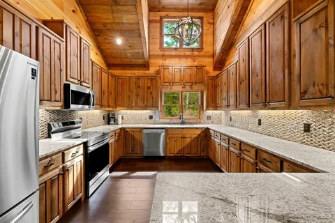 a dining hall with stainless steel appliances kitchen island granite countertop a dining table and chairs
