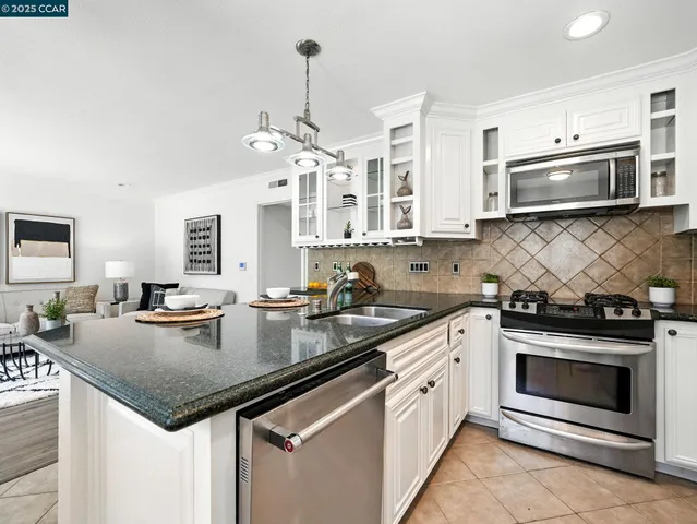 a kitchen with stainless steel appliances granite countertop a stove sink microwave and cabinets