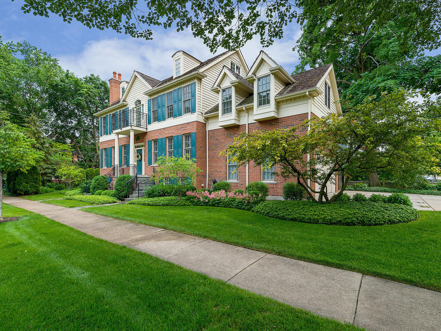 a front view of a house with a yard and trees