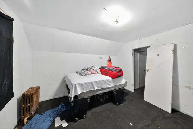 a bed room with a bed and a chair