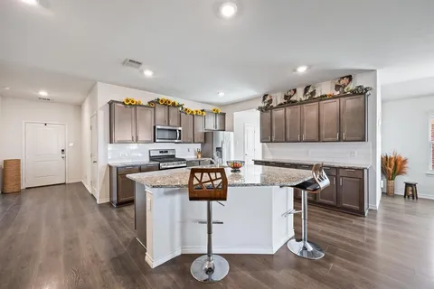 a kitchen with a table chairs refrigerator and cabinets
