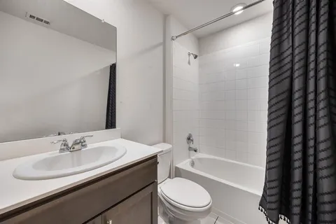 a bathroom with a sink a toilet a mirror a bathtub and shower