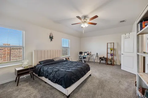 a spacious bedroom with a bed a window and a chandelier